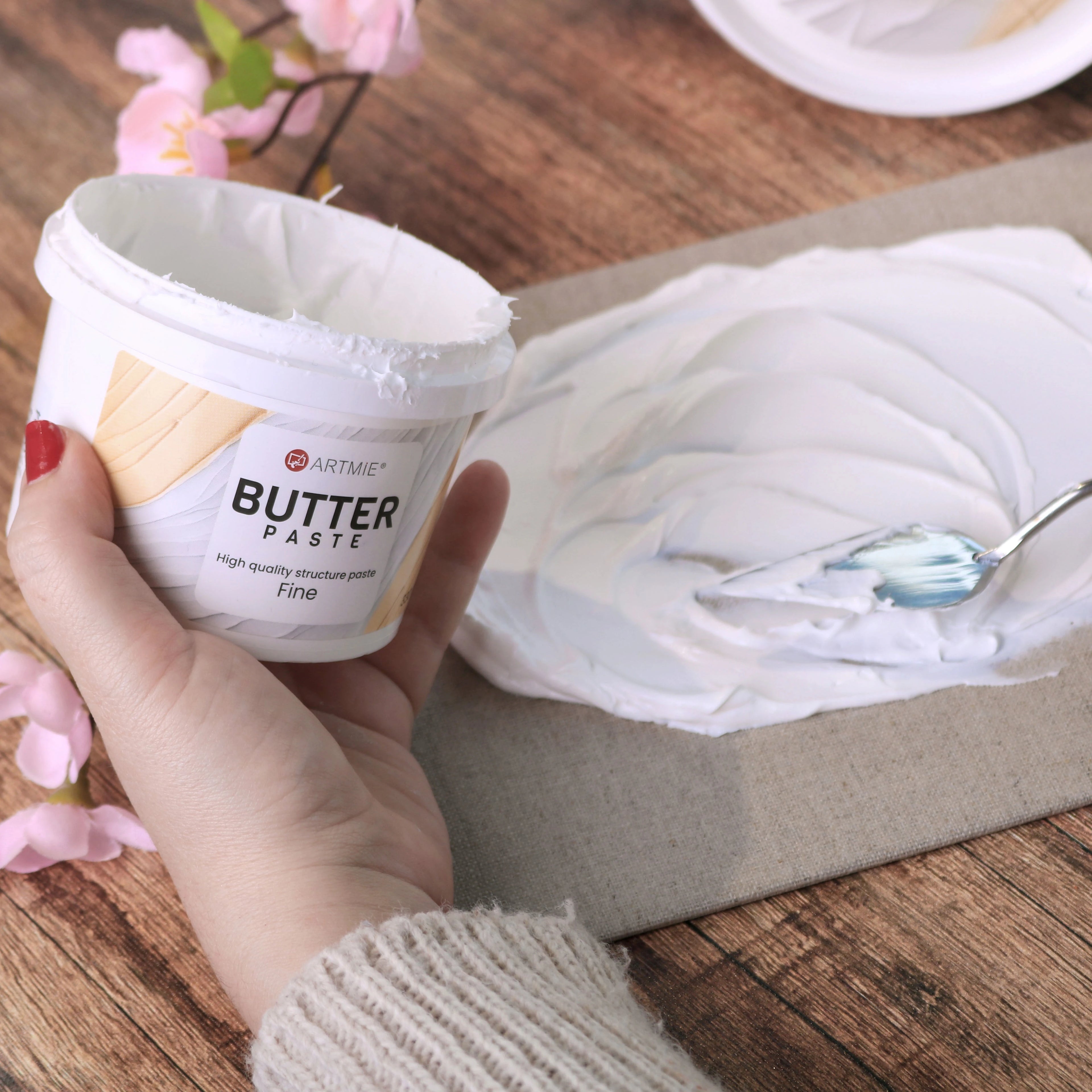 Otvorena kantica i sloj ARTMIE Butter Fine paste nanet na platno slikarskim nožem